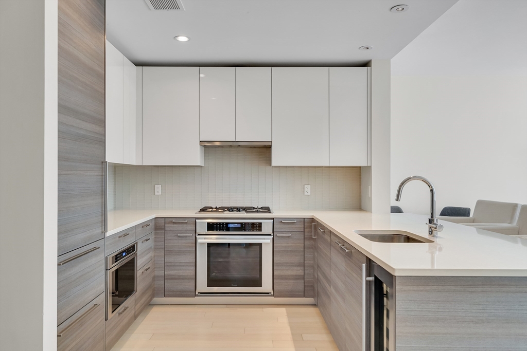 1 Franklin Street, Unit 2409 Boston, MA 02110 - Photo 3 of 19 a kitchen with stainless steel appliances granite countertop a sink stove and cabinets