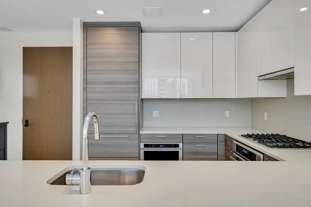 a kitchen with stainless steel appliances granite countertop a sink and a stove