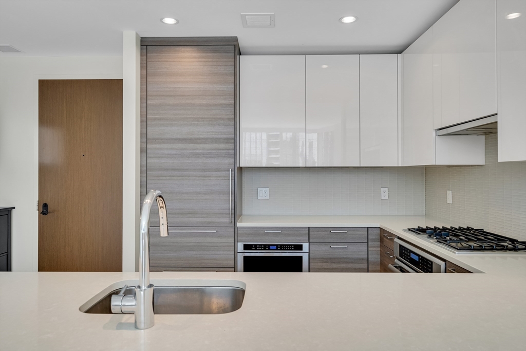 1 Franklin Street, Unit 2409 Boston, MA 02110 - Photo 4 of 19 a kitchen with stainless steel appliances granite countertop a sink and a stove