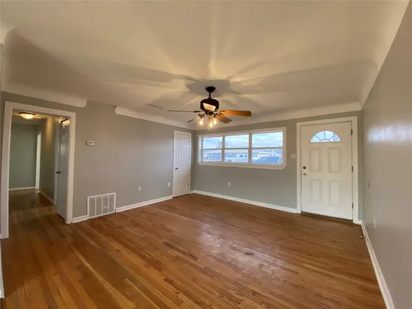 wooden floor in an empty room with a window