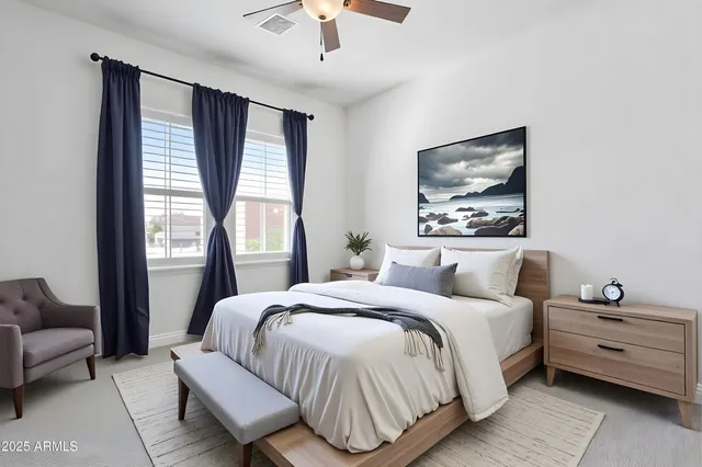 an empty room with chandelier fan and windows
