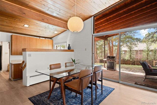 a view of a dining room with furniture a chandelier and wooden floor