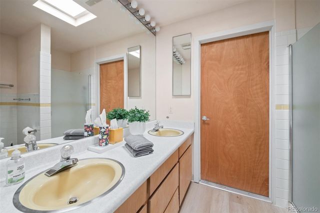 a bathroom with a double vanity sink toilet mirror and shower