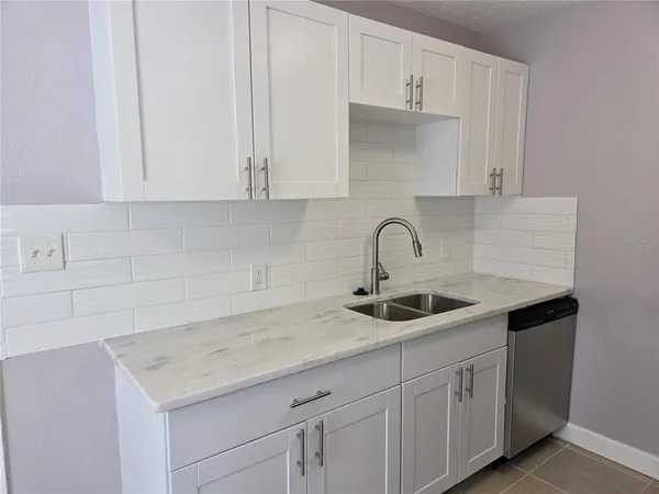 a kitchen with white cabinets and a sink