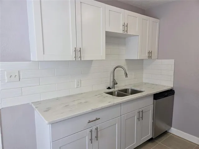 a kitchen with white cabinets and a sink