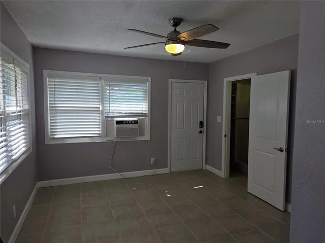 an empty room with windows and closet