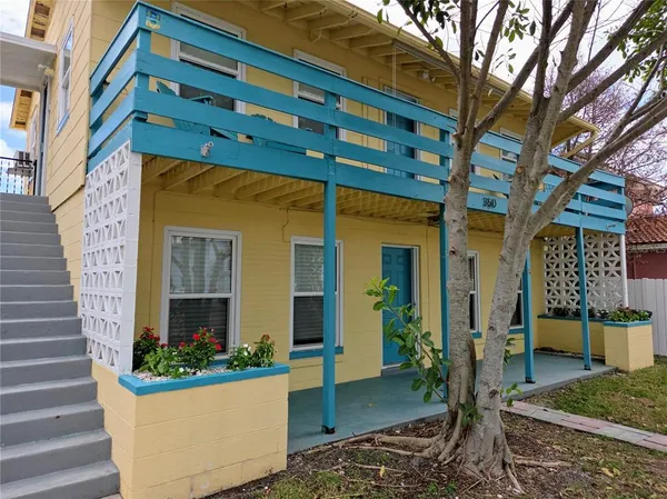 a view of a house with a potted plants and a bench