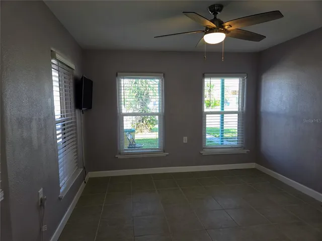 an empty room with a window and a fan