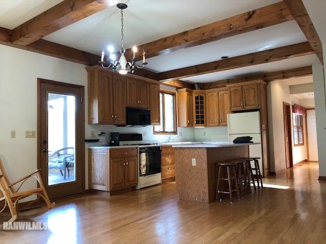 8 Heatherdowns Lane Galena, IL 61036 - Photo 10 of 39 a kitchen with stainless steel appliances granite countertop a stove top oven a refrigerator a dining table and chairs with wooden floor