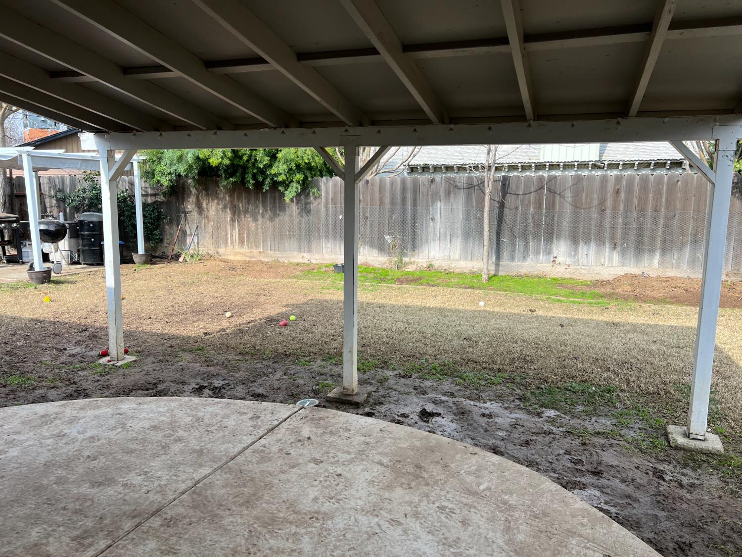 1143 Brownie Court Merced, CA 95340 - Photo 24 of 27 a backyard of a house with table and chairs under an umbrella