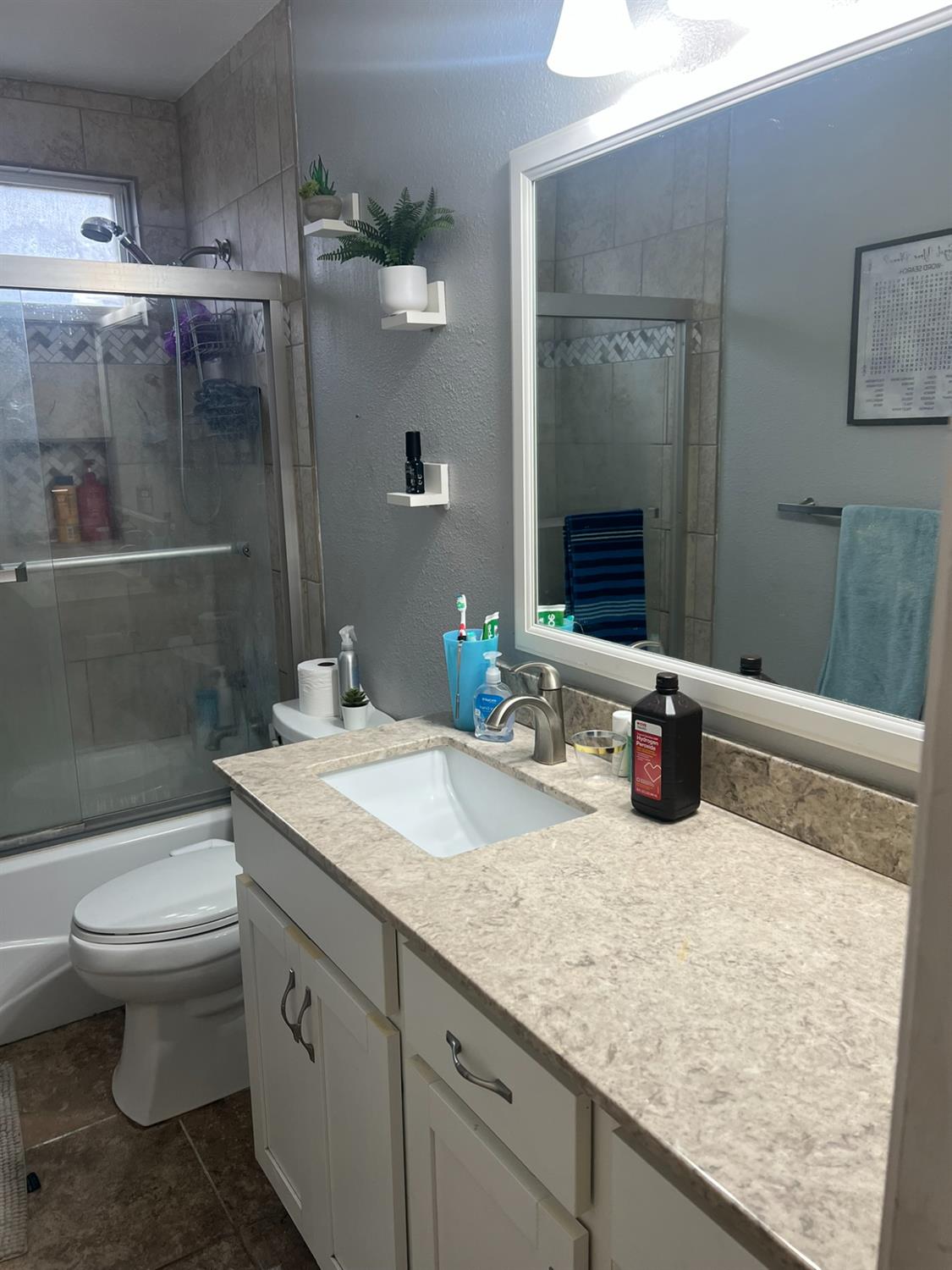 1143 Brownie Court Merced, CA 95340 - Photo 5 of 27 a bathroom with a granite countertop sink a toilet and shower