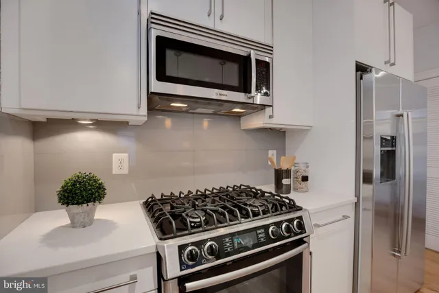 a kitchen with stainless steel appliances kitchen island a stove and a refrigerator