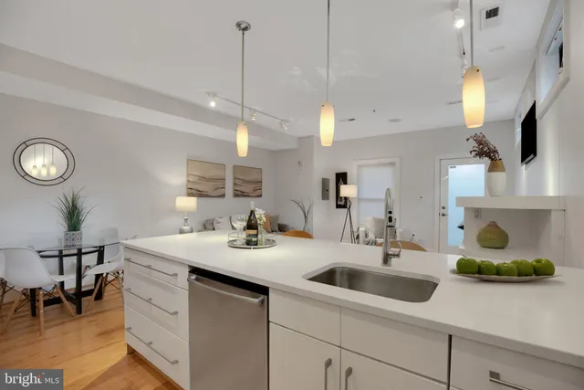 a kitchen with a sink a counter space appliances and cabinets