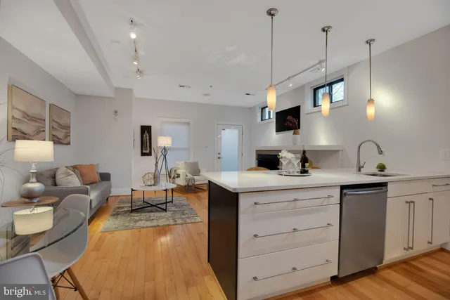a living room with furniture a flat screen tv and kitchen view