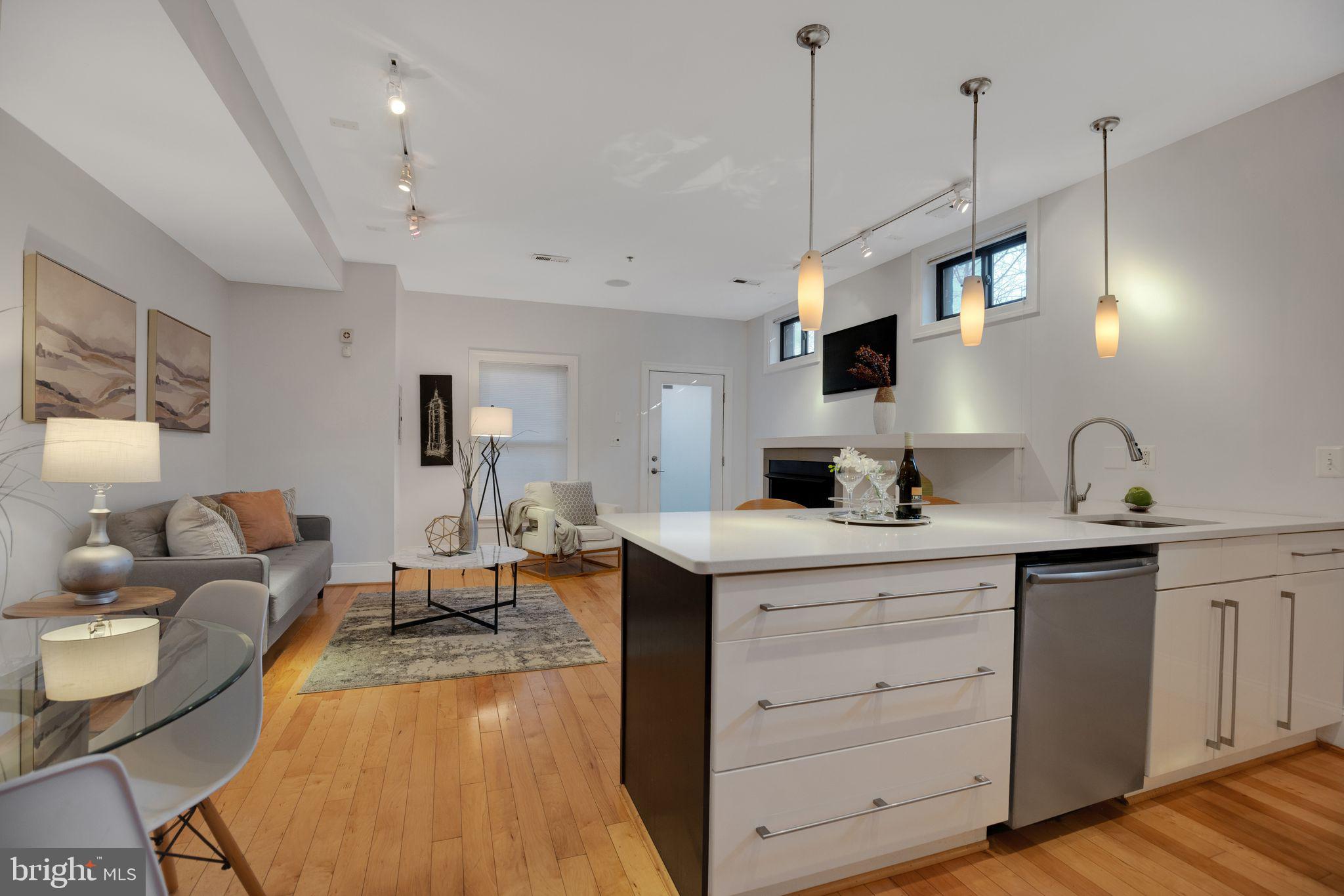 2106 10th Street Northwest, Unit 1 Washington, DC 20001 - Photo 15 of 31 a living room with furniture a flat screen tv and kitchen view