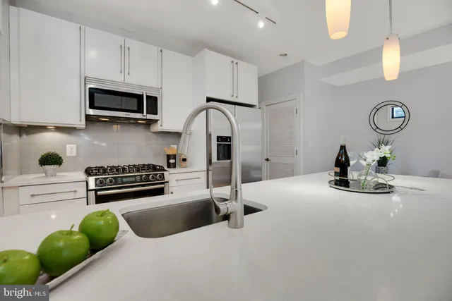 a kitchen with stainless steel appliances granite countertop a sink a stove and cabinets