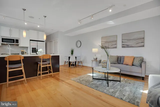 a living room with furniture a table and kitchen view