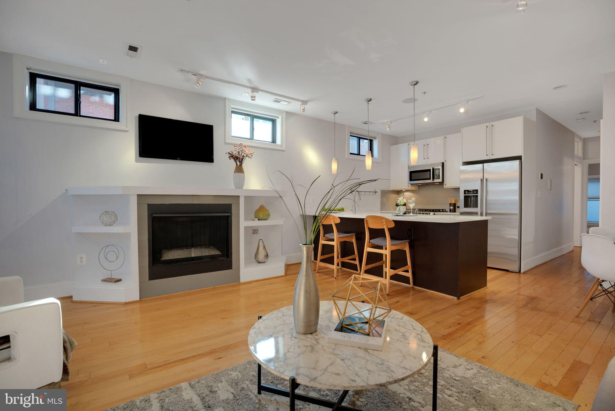 2106 10th Street Northwest, Unit 1 Washington, DC 20001 - Photo 4 of 31 a kitchen with kitchen island a stove a microwave a dining table and chairs
