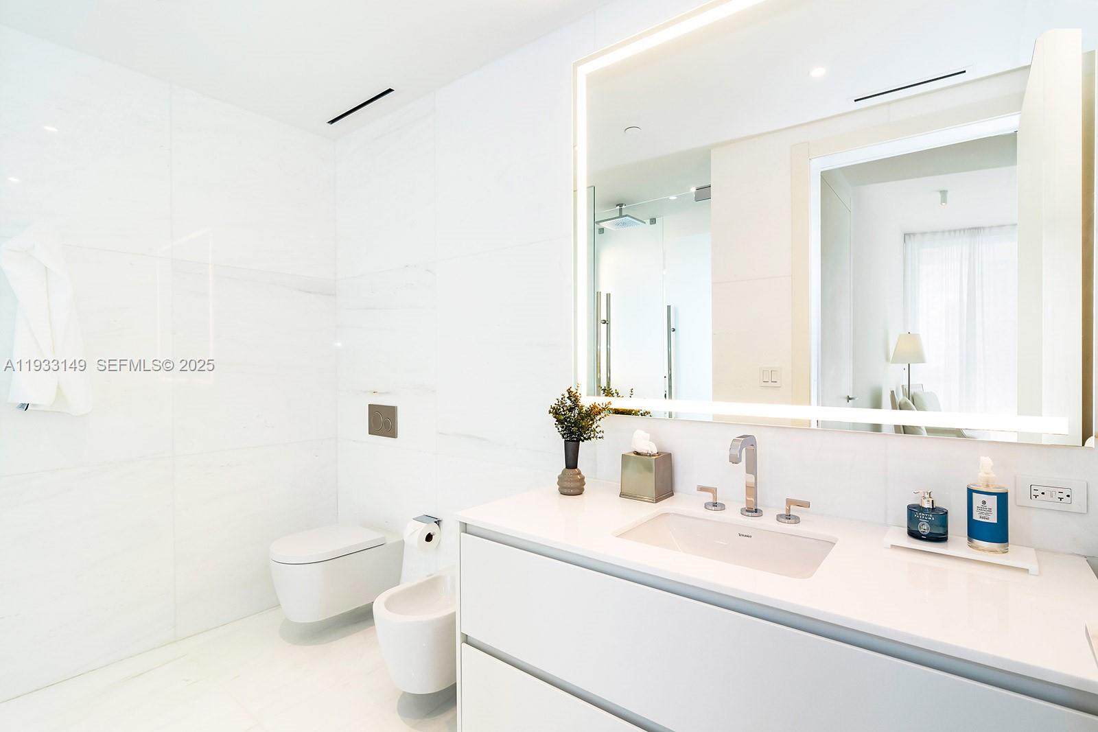 300 Biscayne Blvd Way, Unit 1901 Miami, FL 33131 - Photo 33 of 57 a bathroom with a sink a toilet and a mirror