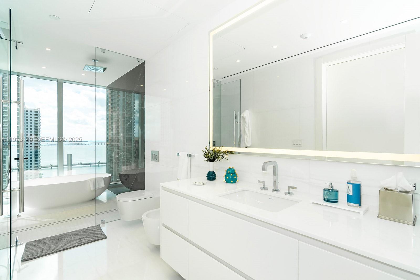 300 Biscayne Blvd Way, Unit 1901 Miami, FL 33131 - Photo 35 of 57 a bathroom with a sink a toilet and a large mirror next to a window