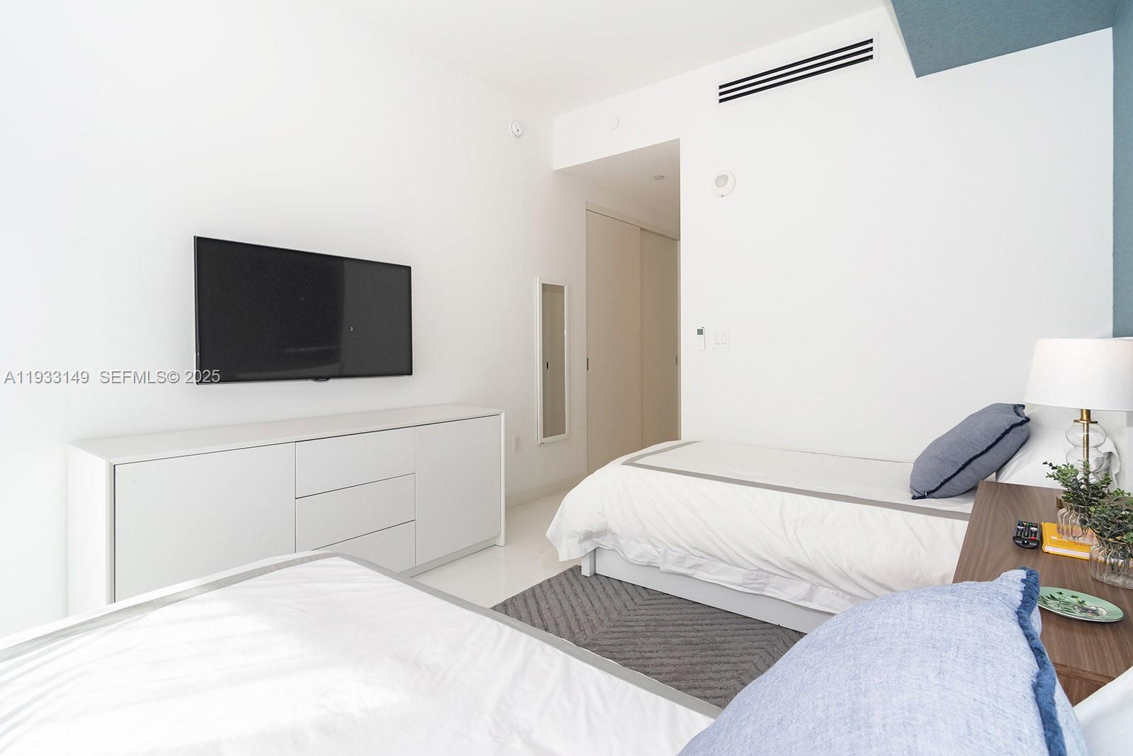 300 Biscayne Blvd Way, Unit 1901 Miami, FL 33131 - Photo 39 of 57 a bedroom with a bed and a flat screen tv