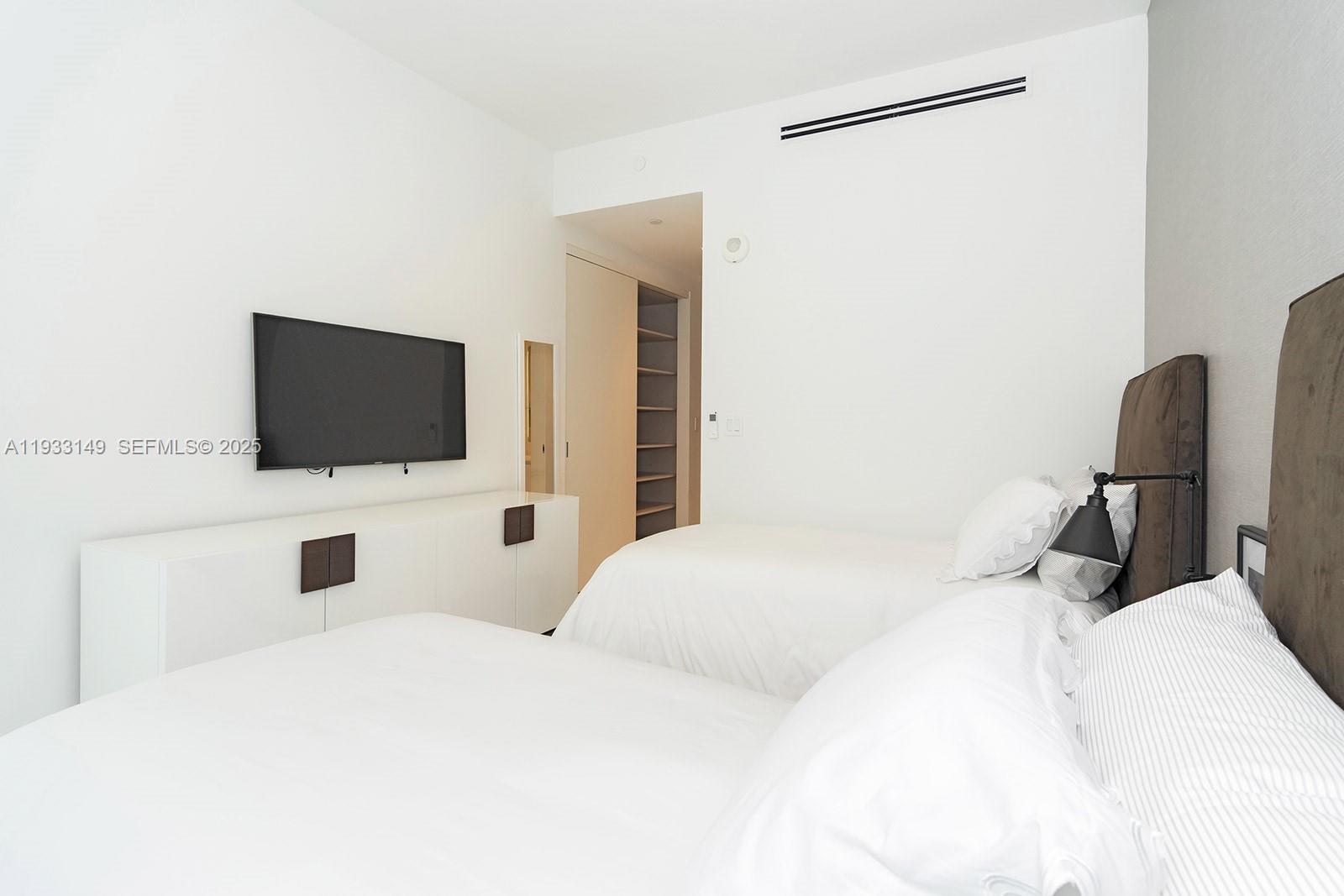 300 Biscayne Blvd Way, Unit 1901 Miami, FL 33131 - Photo 48 of 57 a bedroom with a bed tv and chair