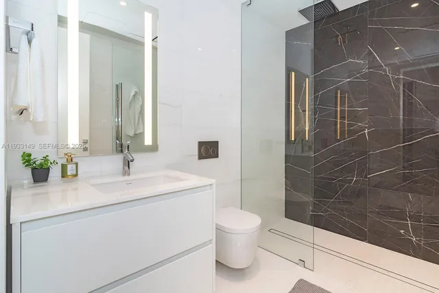 a bathroom with a sink a toilet and mirror