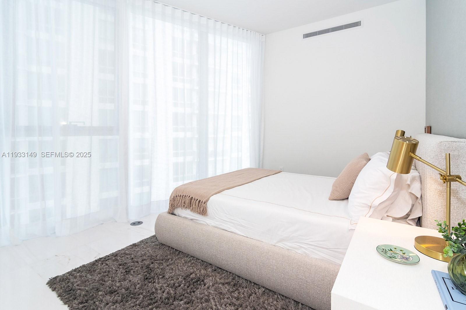 300 Biscayne Blvd Way, Unit 1901 Miami, FL 33131 - Photo 51 of 57 a bedroom with a bed and a window