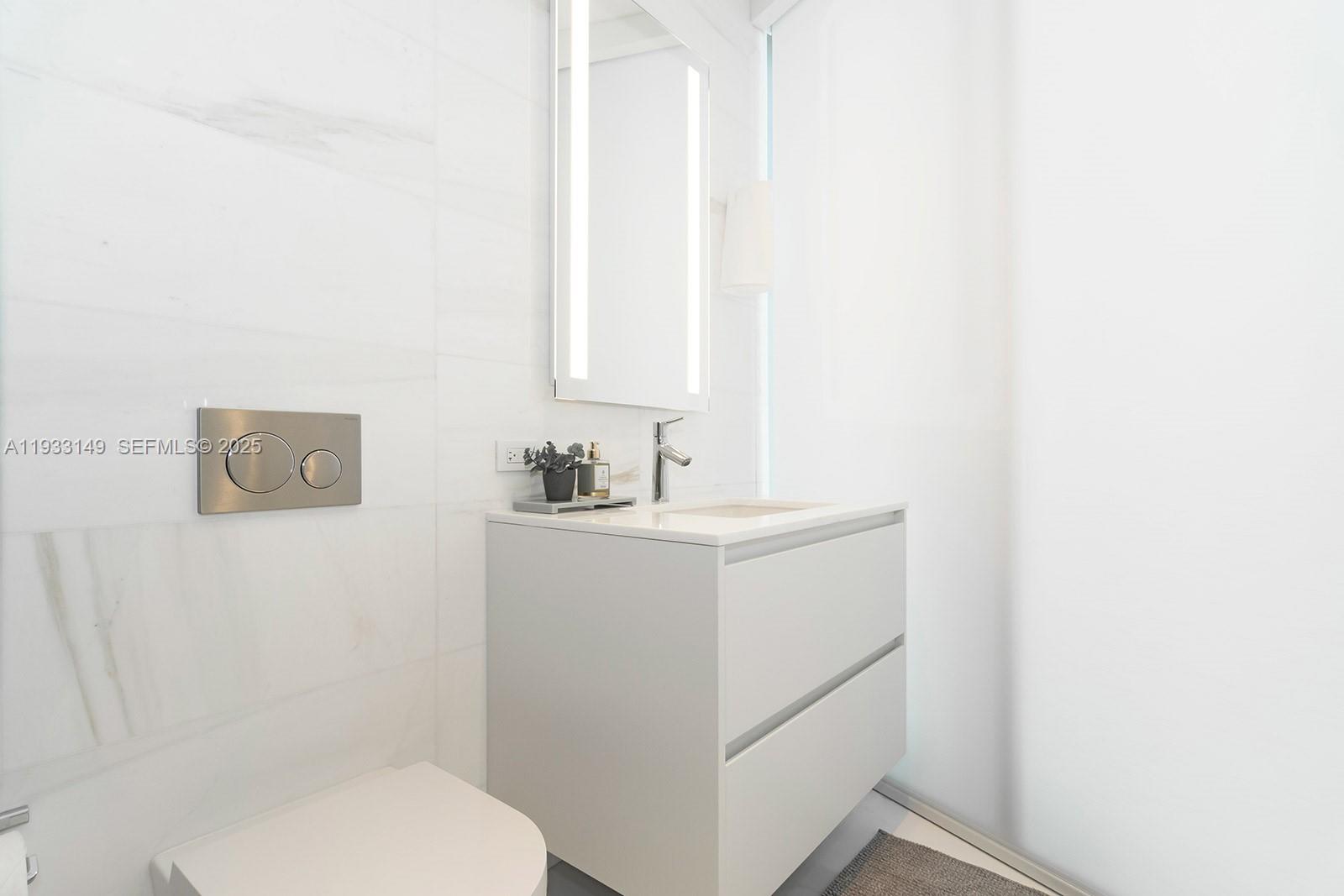 300 Biscayne Blvd Way, Unit 1901 Miami, FL 33131 - Photo 56 of 57 a bathroom with a sink a toilet and mirror