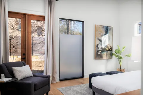 a bedroom with bed and glass window