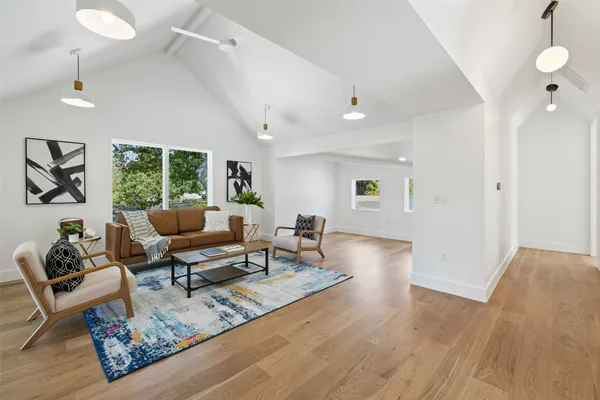 a living room with furniture and a wooden floor