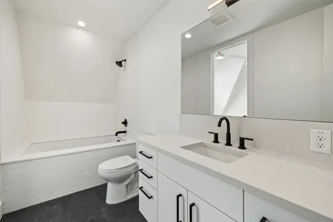 a bathroom with a toilet a sink a mirror and a bathtub