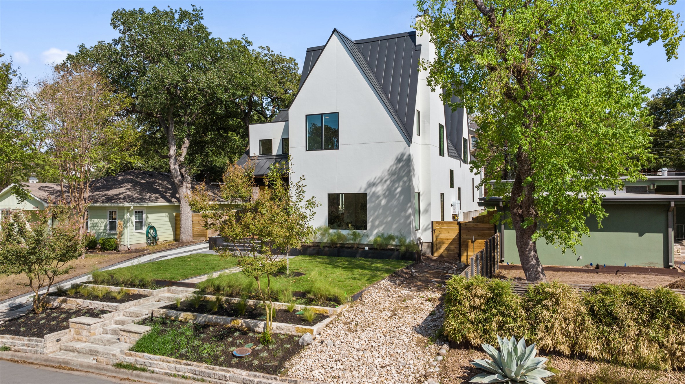 2001 Forest Trail Austin, TX 78703 - Photo 39 of 40 View of front of house featuring stucco siding, a metal roof, and a front lawn