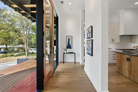 a view of a hallway with wooden floor and windows