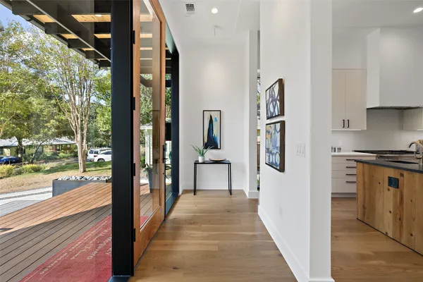 a view of a hallway with wooden floor and windows