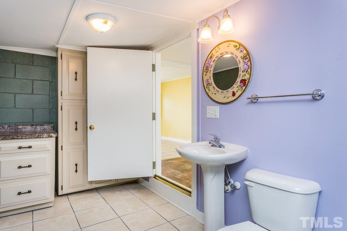 161 Prospect Avenue Raleigh, NC 27603 - Photo 13 of 24 a bathroom with a sink a mirror and a toilet