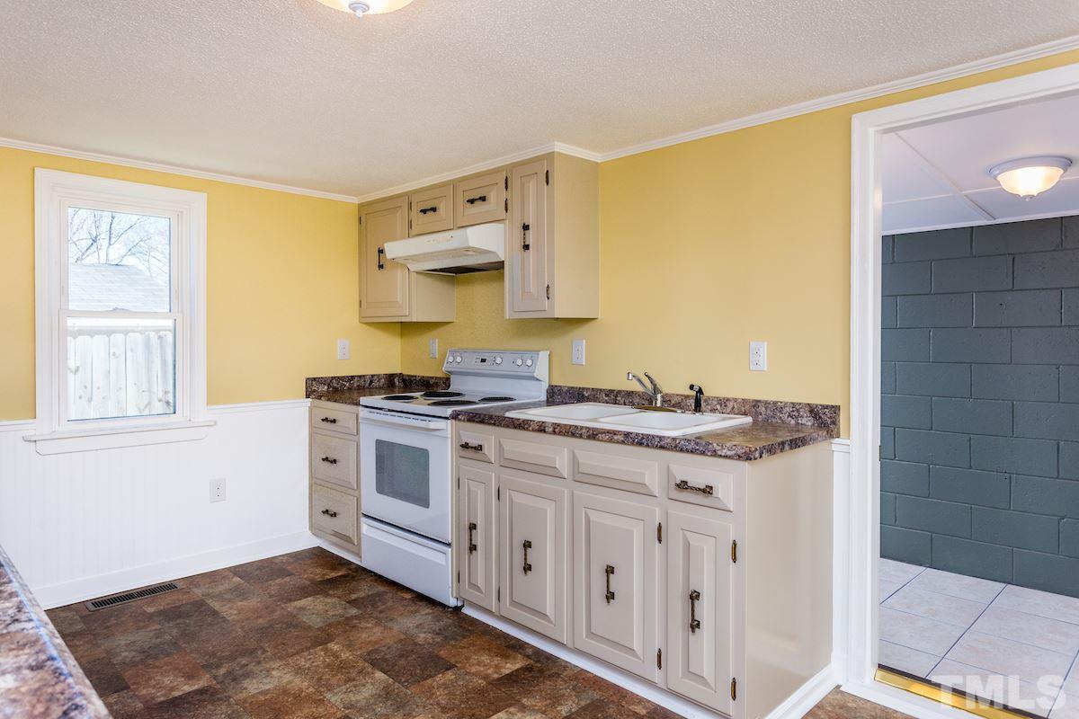 161 Prospect Avenue Raleigh, NC 27603 - Photo 7 of 24 a kitchen with stainless steel appliances granite countertop a stove and a white cabinets