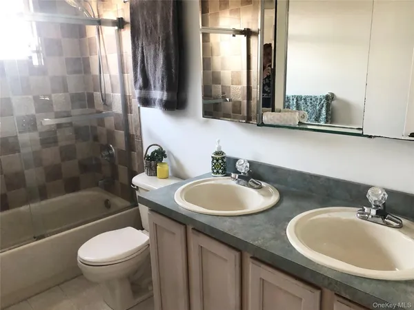 a bathroom with a granite countertop toilet and a sink