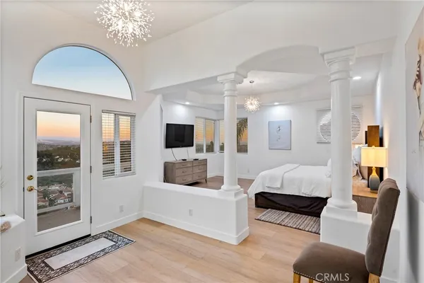 a living room with furniture a chandelier and a flat screen tv