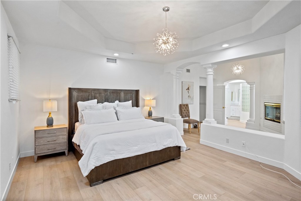 30786 La Mer Laguna Niguel, CA 92677 - Photo 21 of 40 a spacious bedroom with a large bed and a chandelier