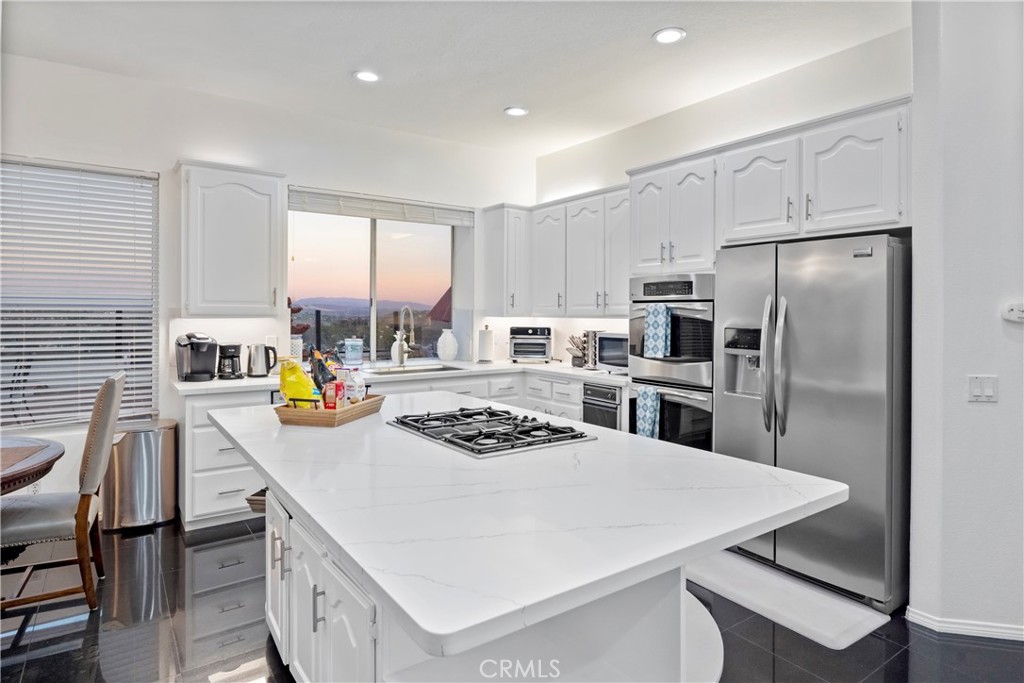 30786 La Mer Laguna Niguel, CA 92677 - Photo 7 of 40 a kitchen with stainless steel appliances granite countertop a stove a refrigerator a sink dishwasher a dining table and chairs with wooden floor