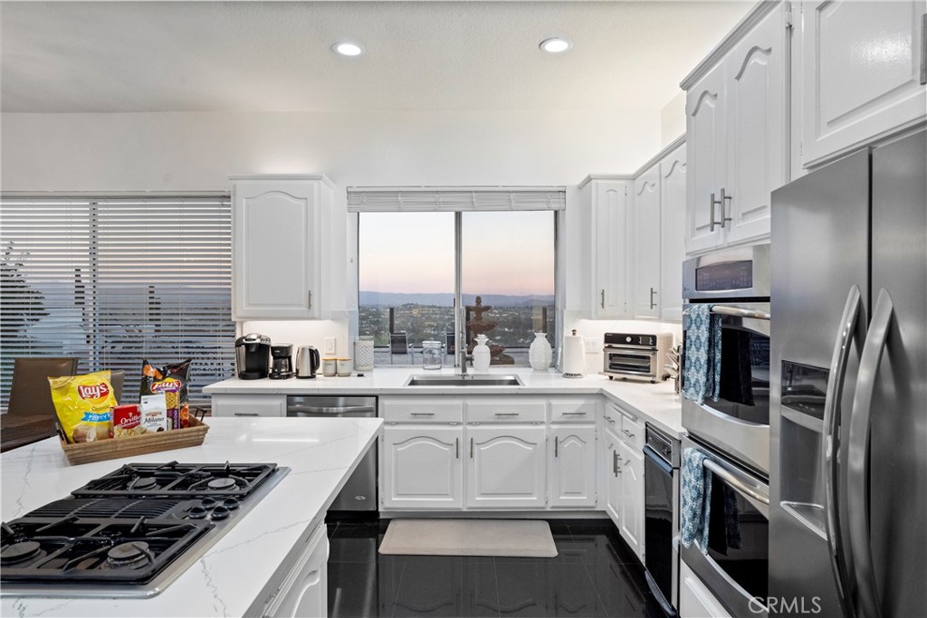 30786 La Mer Laguna Niguel, CA 92677 - Photo 9 of 40 a kitchen with stainless steel appliances a stove sink microwave and cabinets