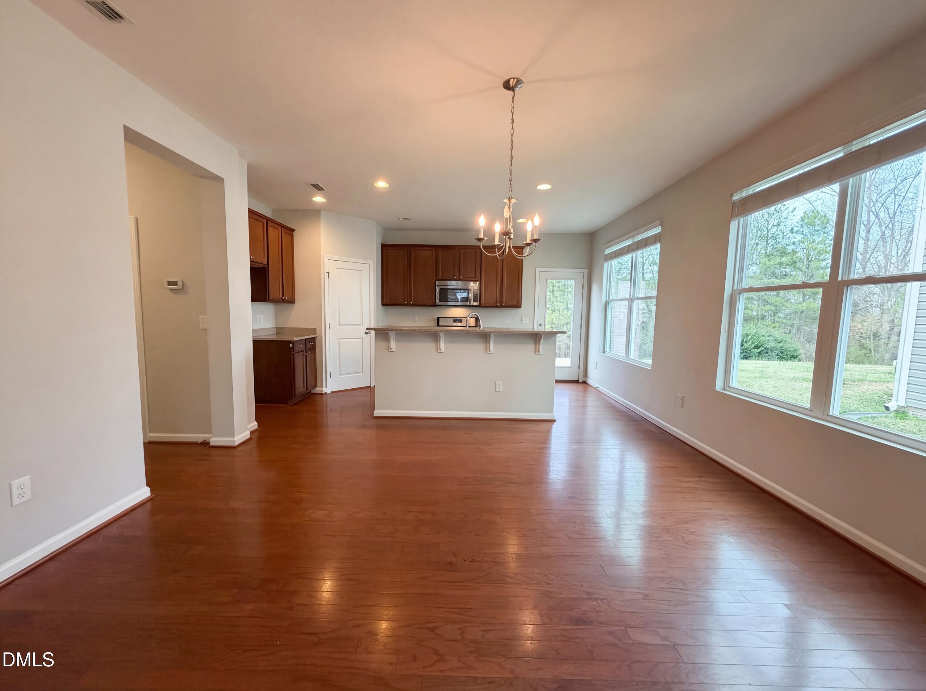 3933 Massey Run Raleigh, NC 27616 - Photo 11 of 19 a view of a kitchen and dining room with wooden floor a chandelier