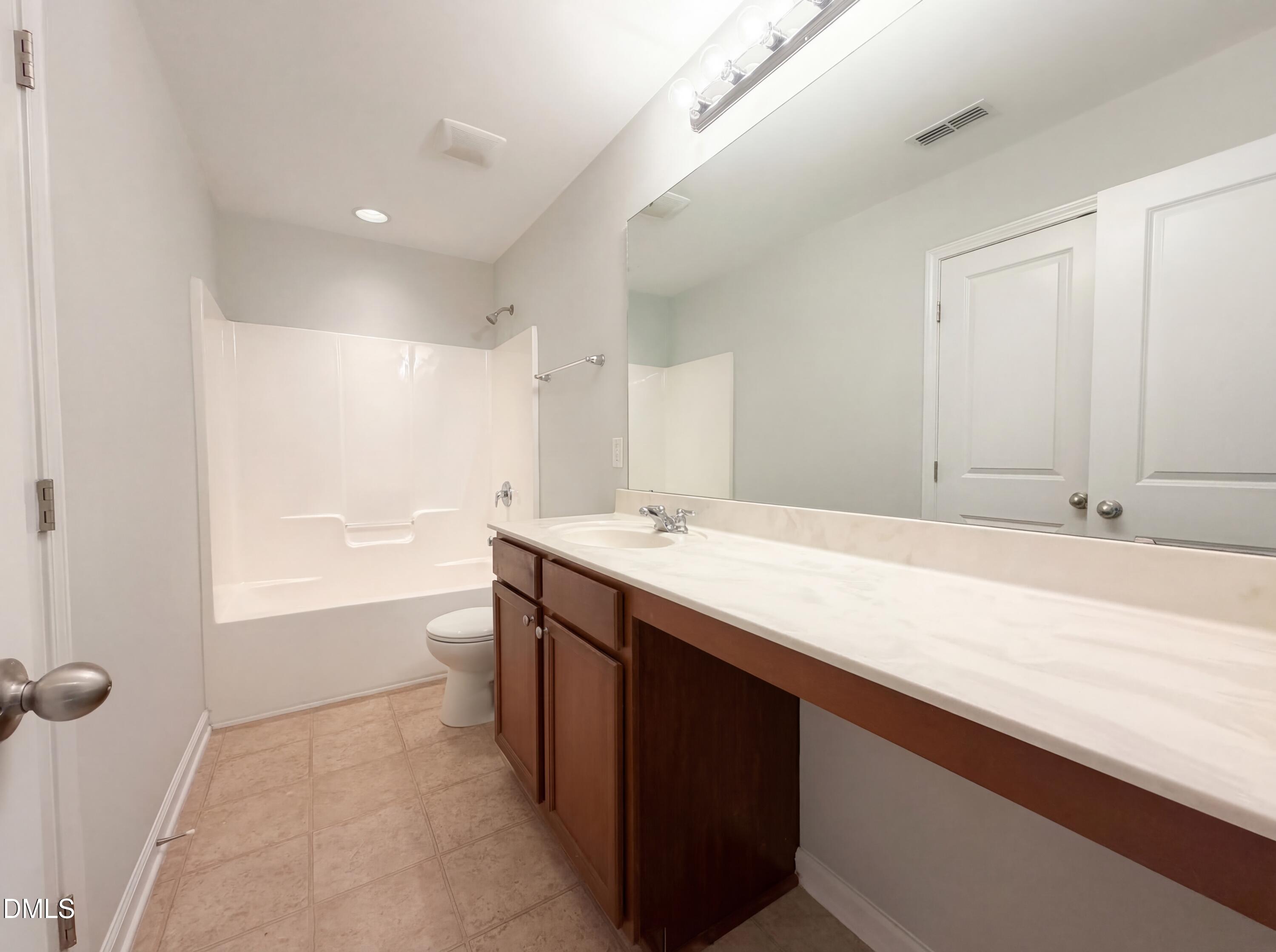 3933 Massey Run Raleigh, NC 27616 - Photo 7 of 19 a bathroom with a sink a vanity a mirror and a bathtub