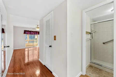 a view of a hallway with wooden floor and closet area