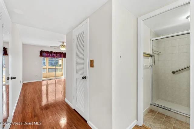 a view of a hallway with wooden floor and closet area