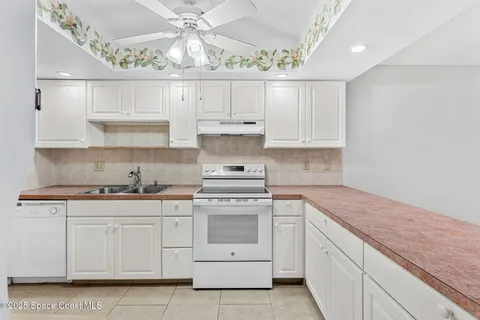 a kitchen with white cabinets and white appliances