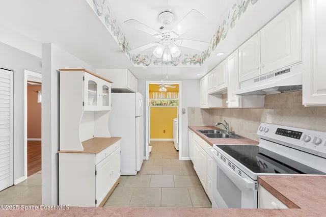 a kitchen with stainless steel appliances a stove a chimney a sink and cabinets