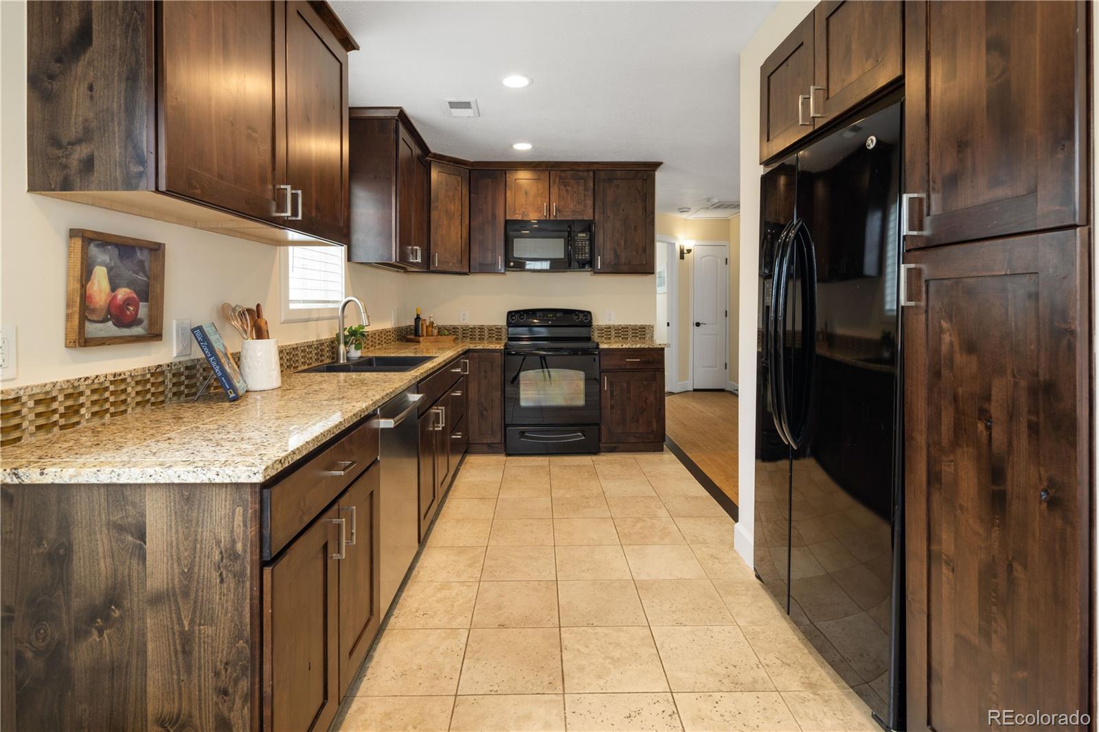 2242 North Lamar Street Edgewater, CO 80214 - Photo 11 of 27 a kitchen with granite countertop stainless steel appliances and wooden cabinets