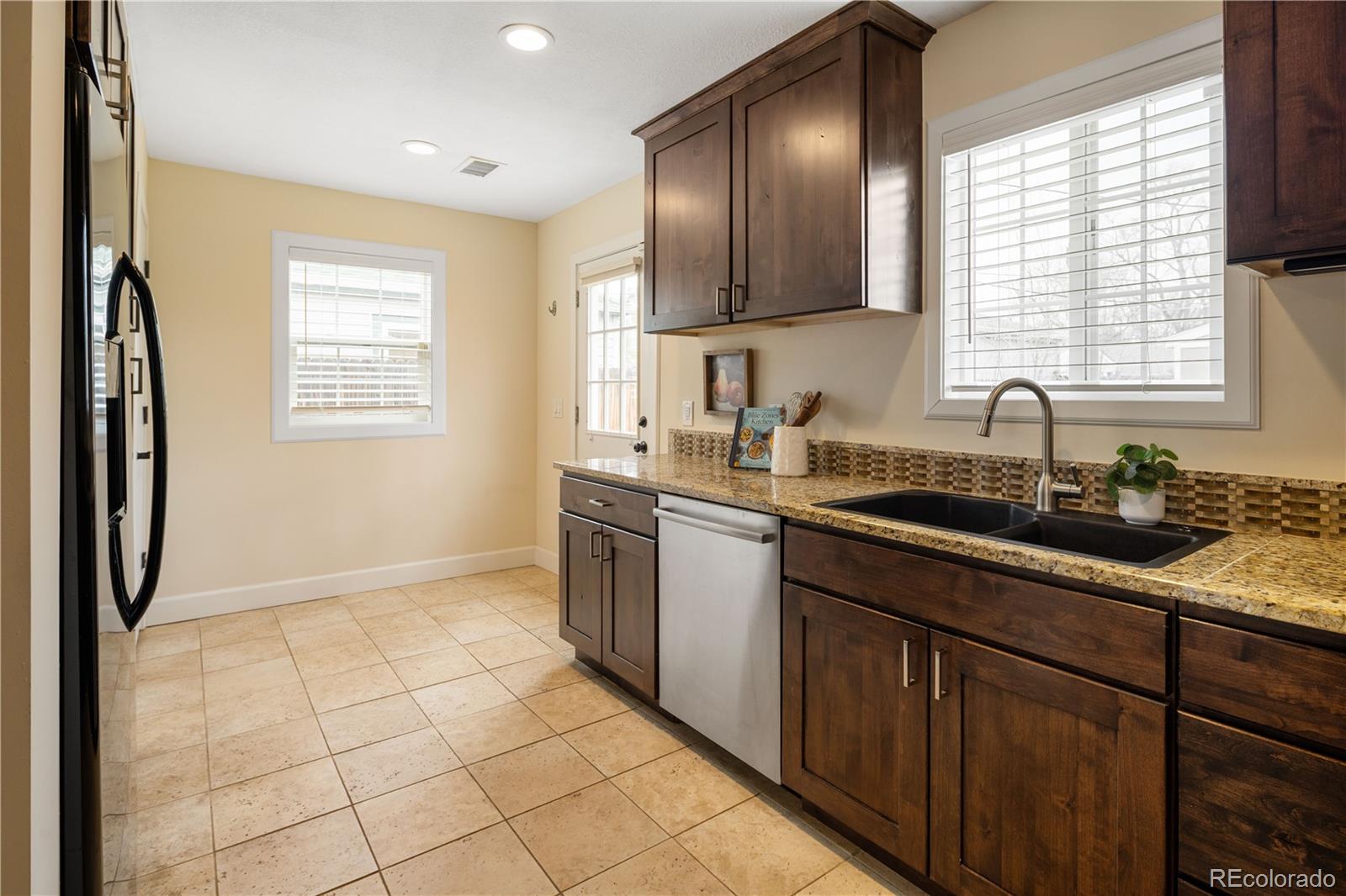 2242 North Lamar Street Edgewater, CO 80214 - Photo 12 of 27 a kitchen with stainless steel appliances granite countertop a sink stove and cabinets